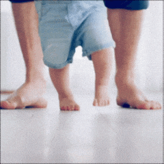 Jambes et pieds d'un bébé qui apprend à marcher