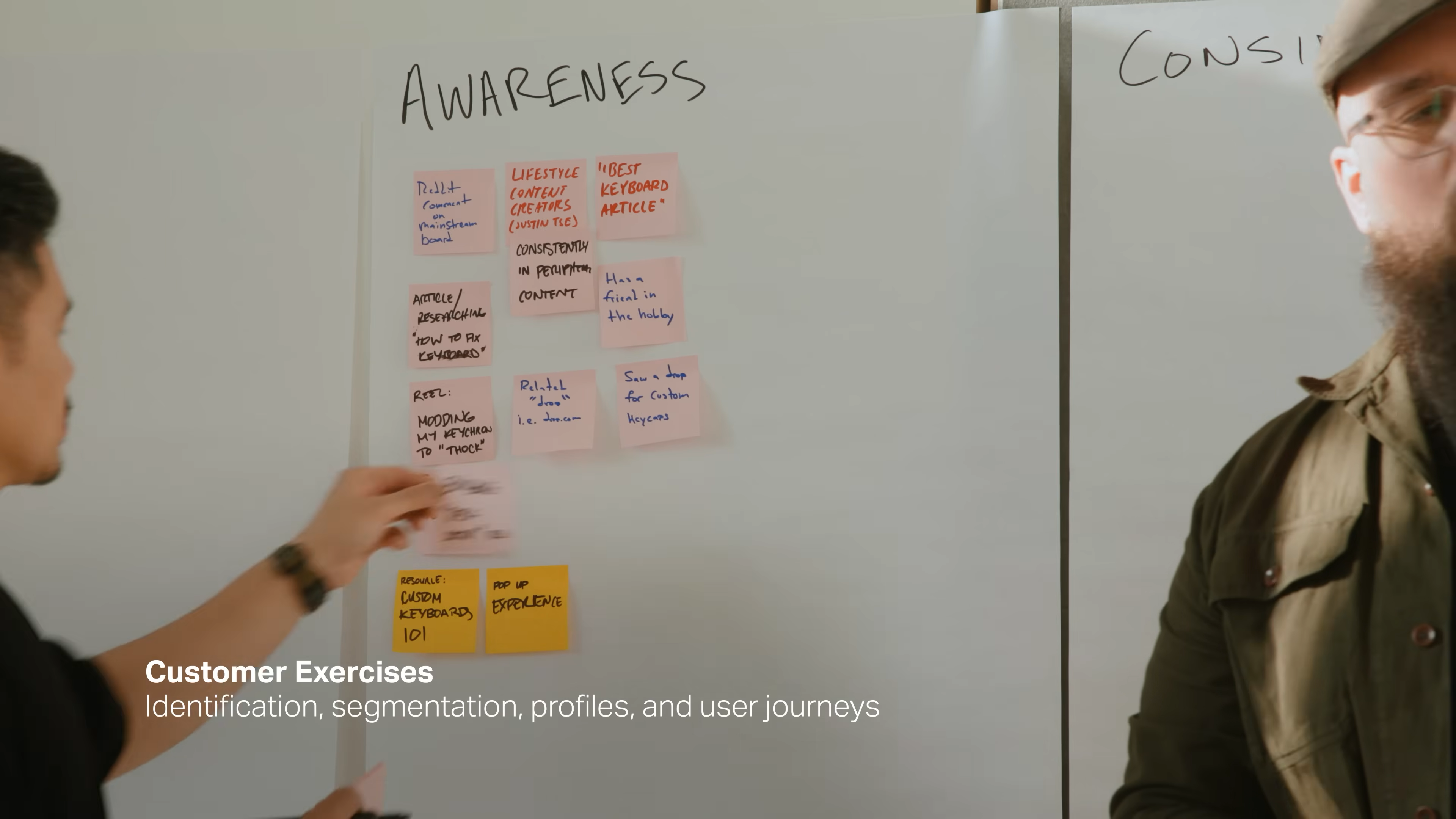 Team member mapping out brand awareness strategies using sticky notes on a whiteboard during Mode’s rebrand workshop, from Matthew Encina’s branding process video.