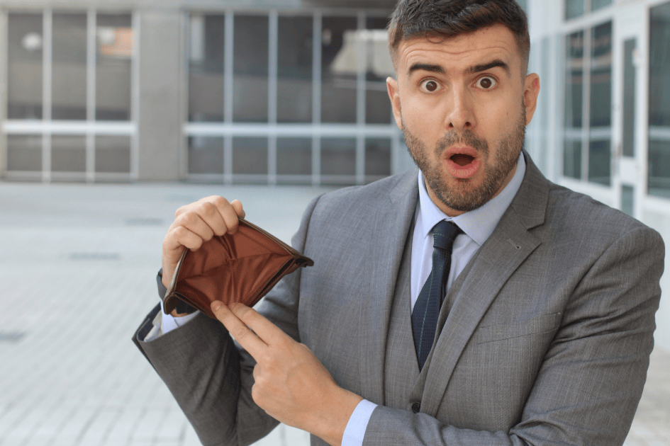 Homme qui montre son porte-monnaie vide et semble surpris