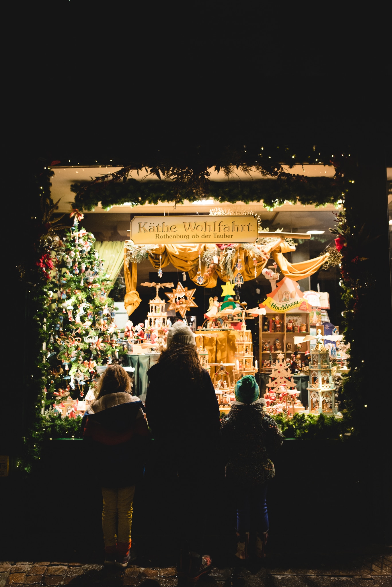 children looking in store window with low light from evening walk