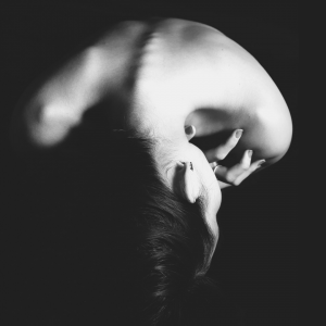 A woman embracing herself to soothe from the effects of trauma.