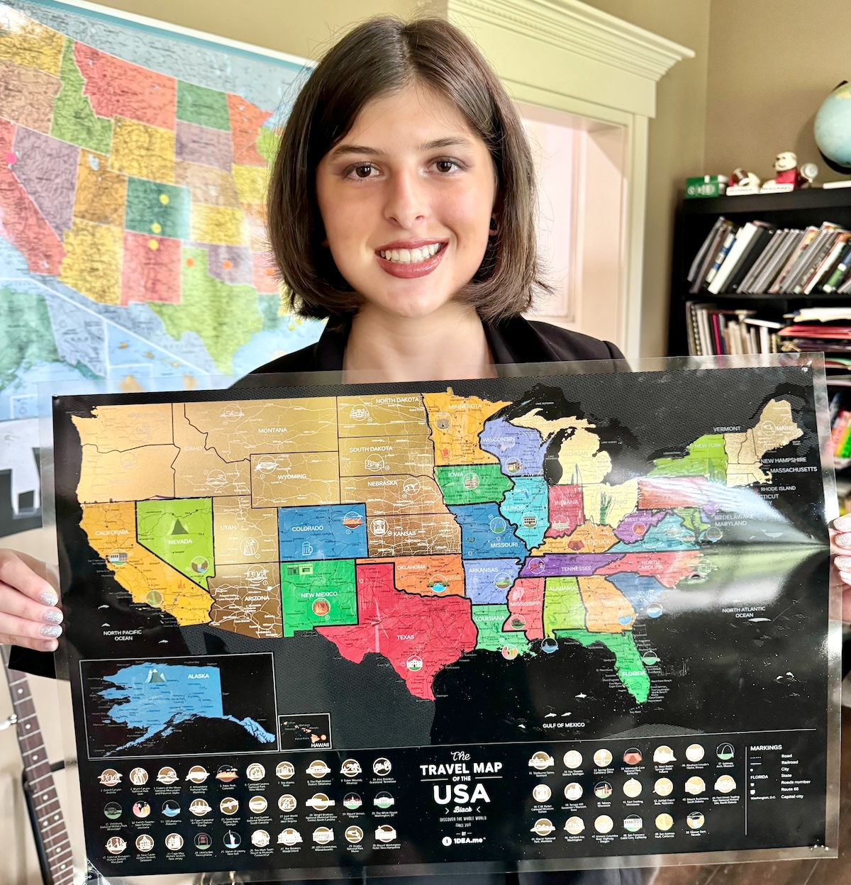 Payton holding her scratch-off map