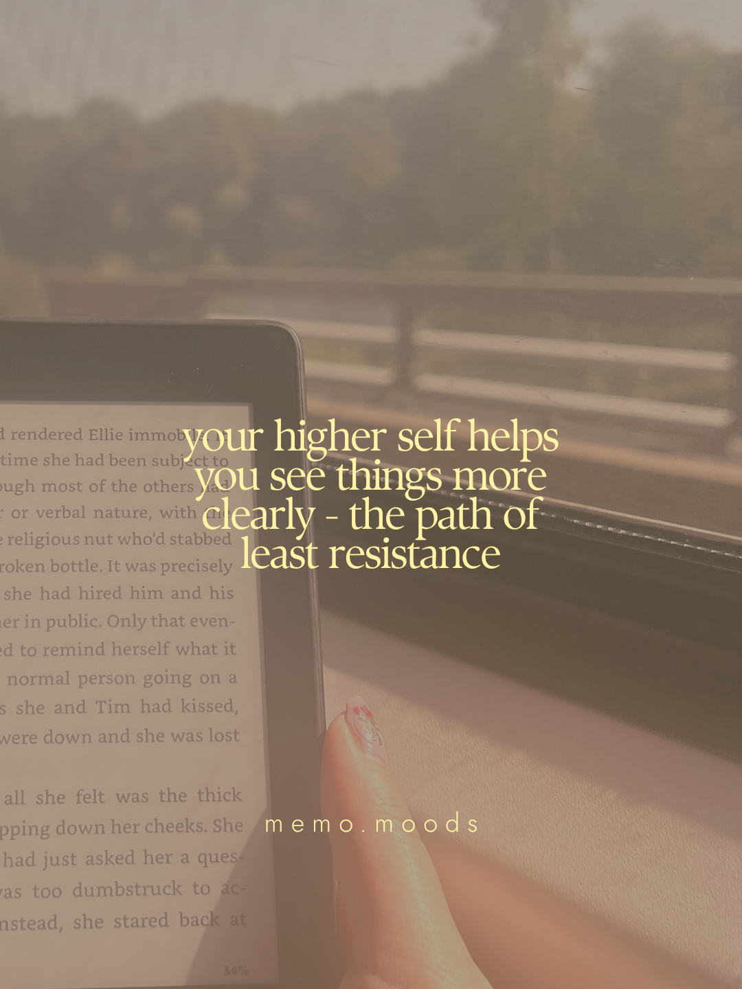 Quote graphic over a cozy photo of a hand holding a Kindle e-reader on a train with a blurred outdoor landscape in the background. Text reads: "your higher self helps you see things more clearly - the path of least resistance." by memo.moods.