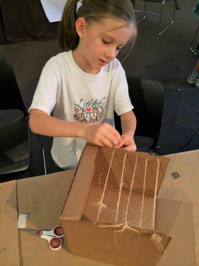 A child creating a roof frame for a miniature succah - a creative idea for teaching ALL-OF-A-KIND FAMILY by Sydney Taylor, from LitWits Workshops