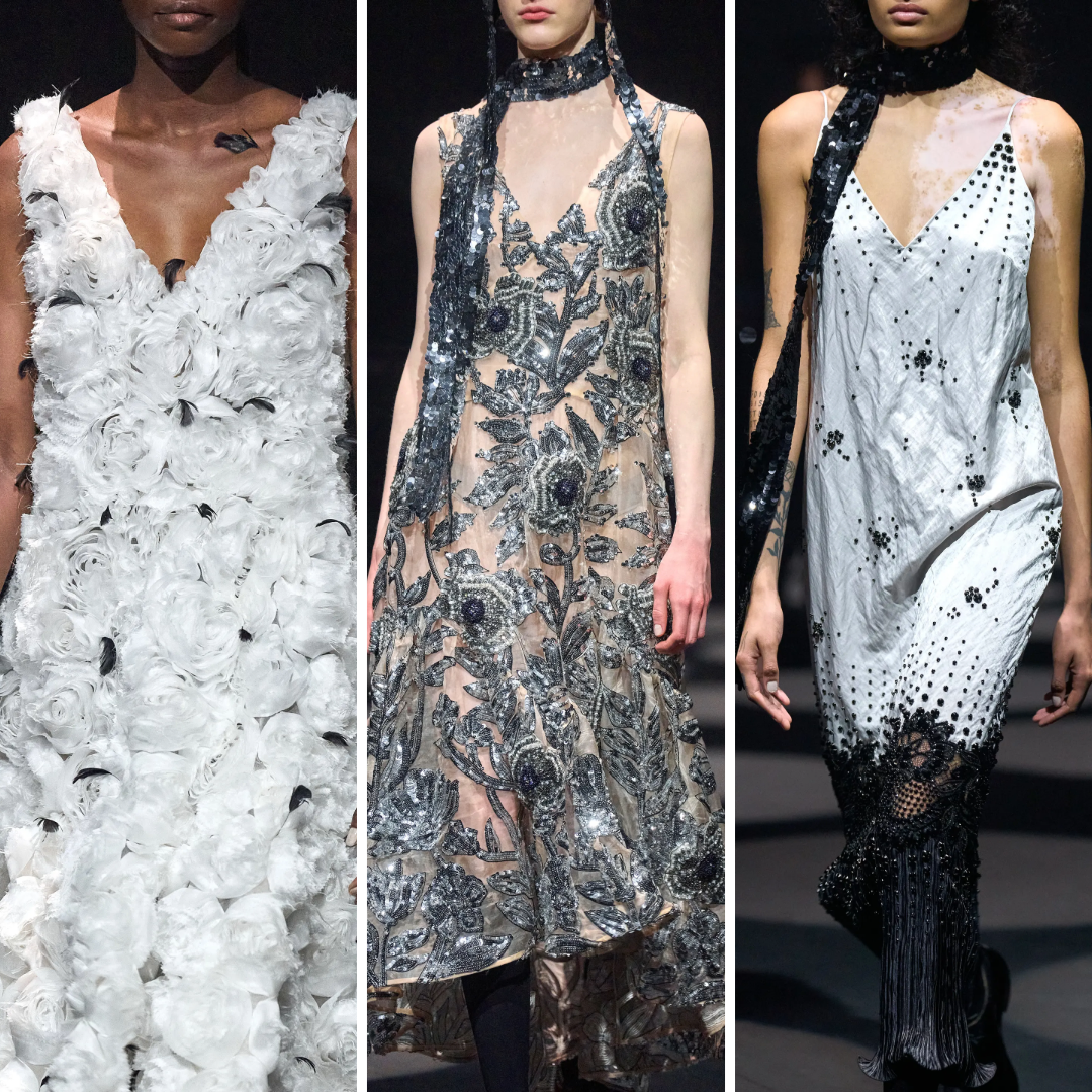 Three embellished runway dresses from Erdem Autumn/Winter 2022: a white 3D floral gown with black feather accents, a sheer tulle dress with silver beaded florals, and a white silk slip covered in micro beadwork and black fringe. These looks explore fragility and defiance through monochrome embroidery and textile layering.