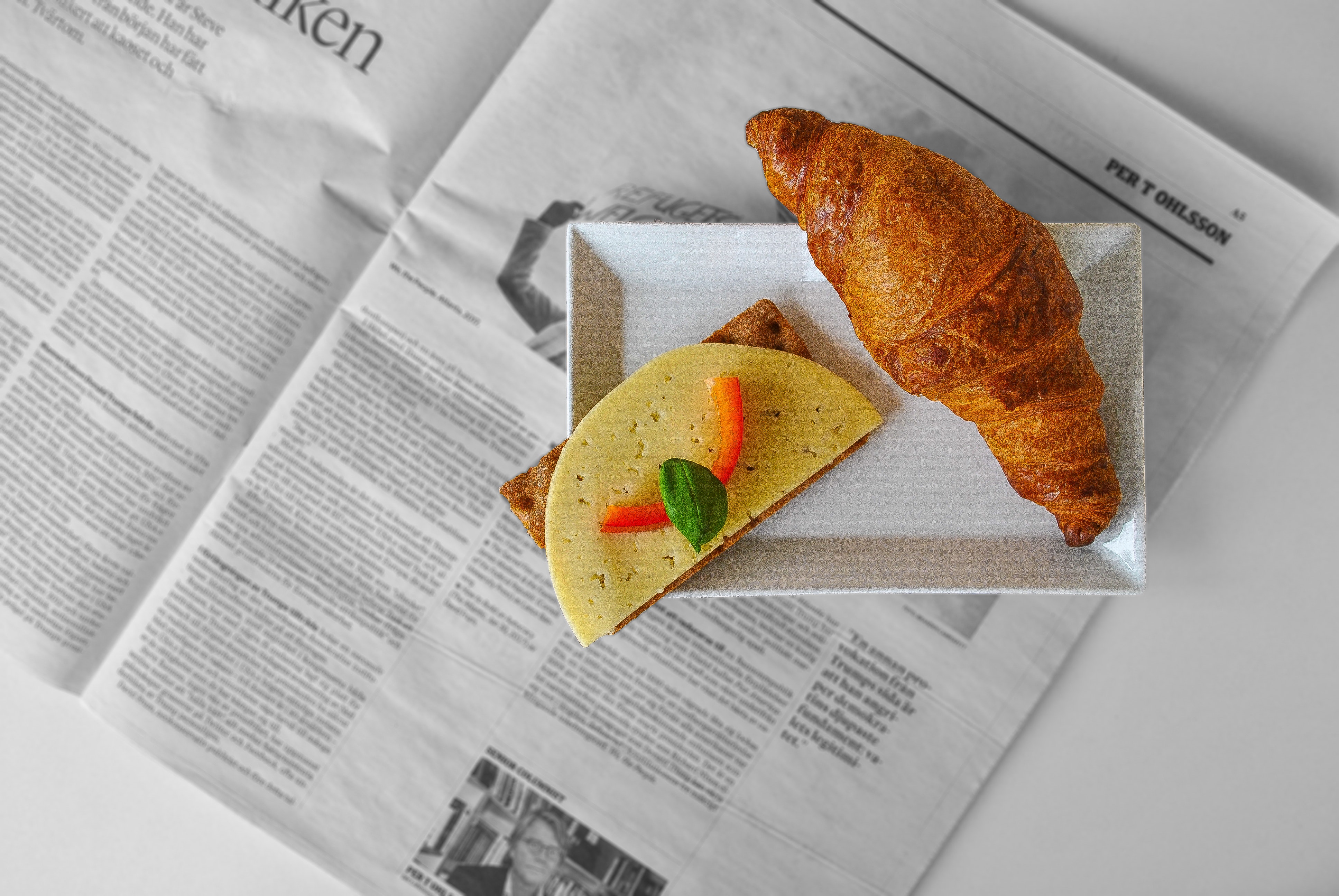 a sandwich lying on a newspaper