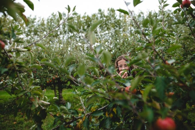 Image of child eating an apple in an orchard. Properly exposed image using the exposure triangle.