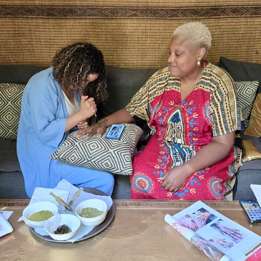 Travelers connecting with locals through henna during a meaningful cultural immersion travel experience