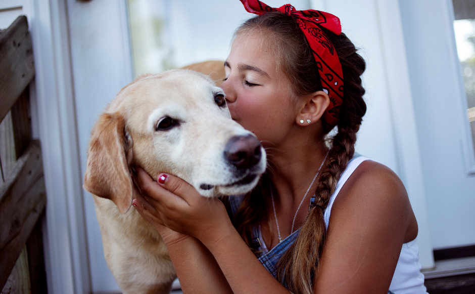 woman kissing dog's cheek