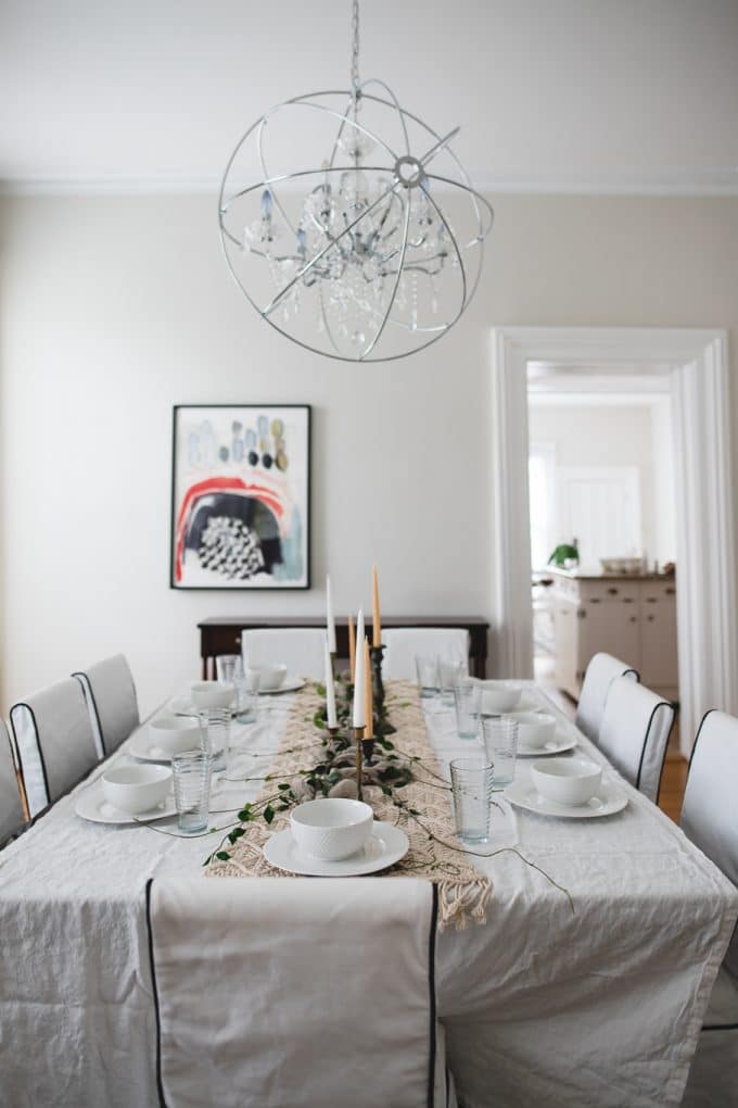 Dining room set up with a white table cloth and dishes set on top. Shows perfect white balance