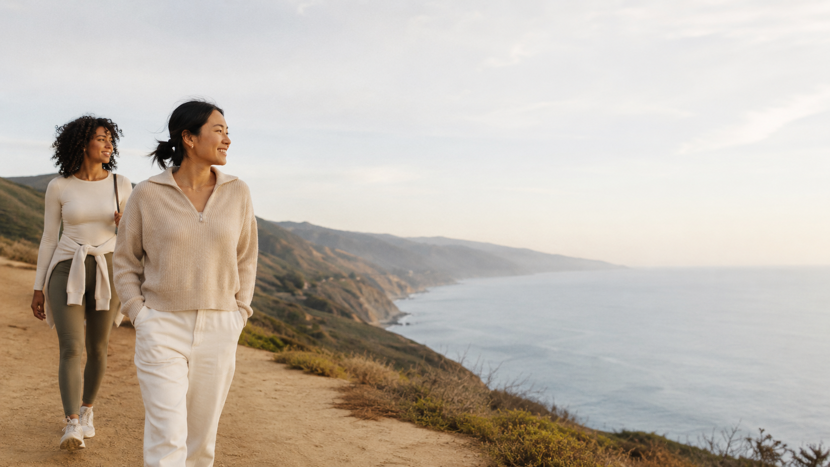 Two women walking a scenic path on a small group trip, each moving at her own pace