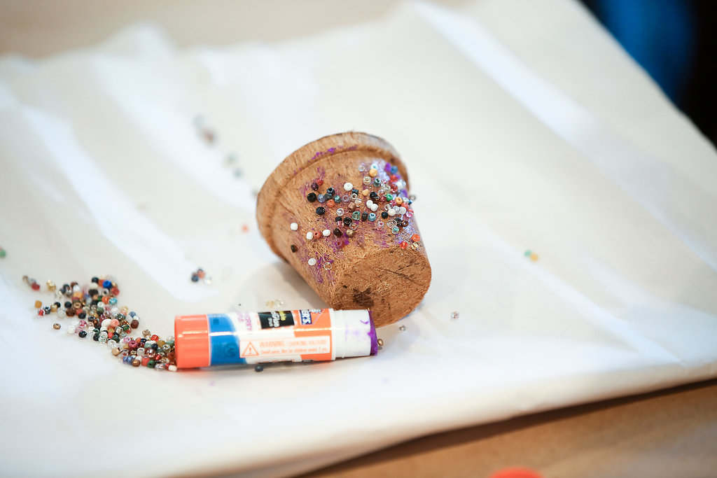 Adding beads to a planting pot for a creative activity for teaching THE BIRCHBARK HOUSE by Louise Erdrich - from LitWits Workshops