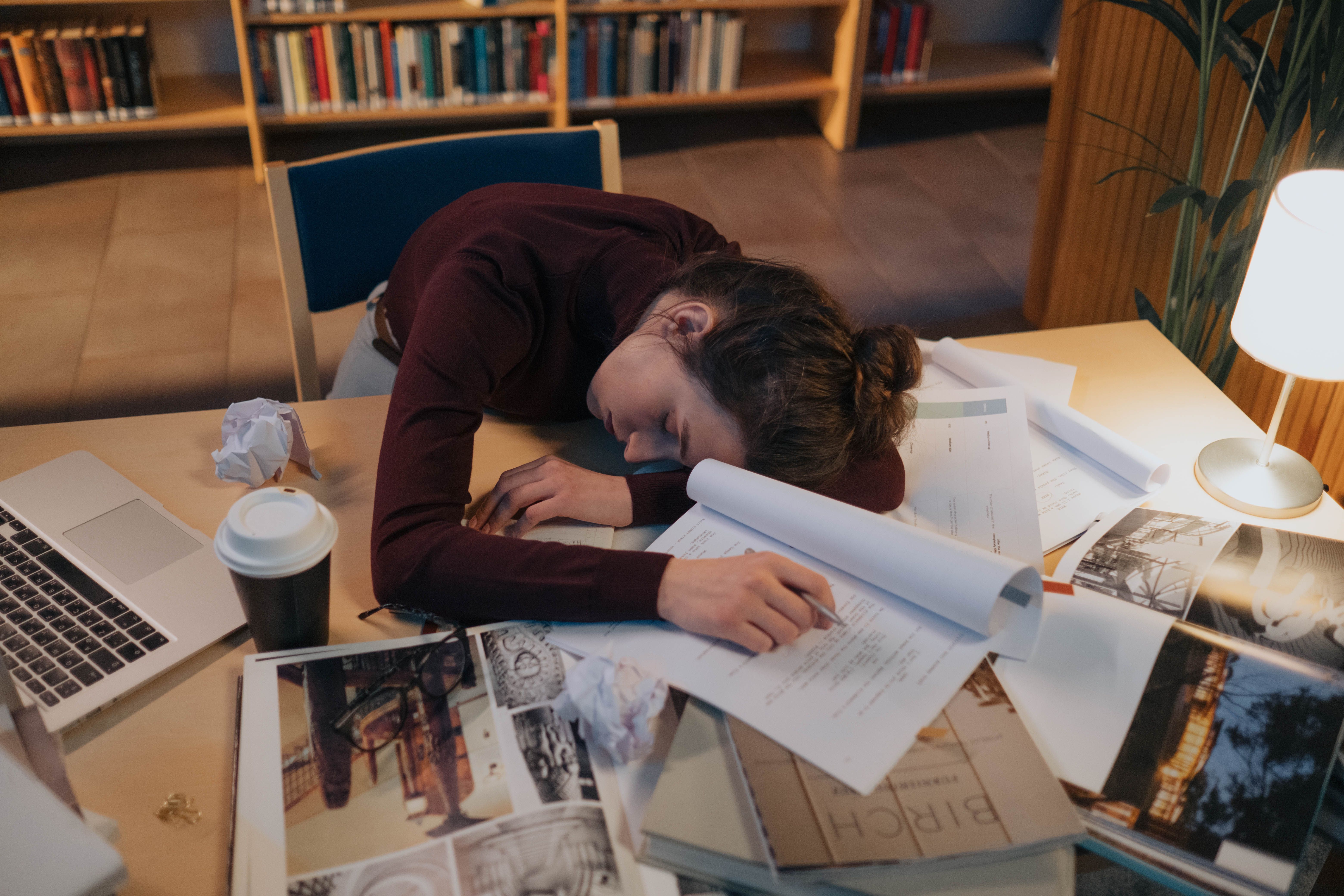 A woman rests with eyes closed or hands still, representing the physiological downregulation the nervous system requires during recovery from burnout.