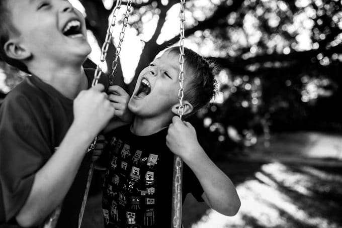 boys on tire swing in candid photography photo