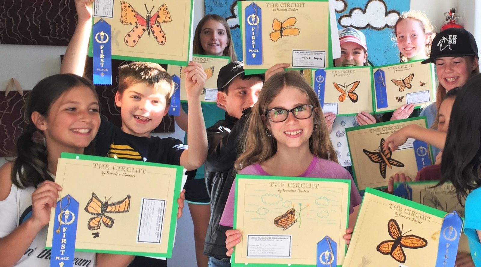 Kids holding up models of the Monarch butterfly art project - a creative idea for teaching THE CIRCUIT by Francisco Jiménez, from LitWits Workshops