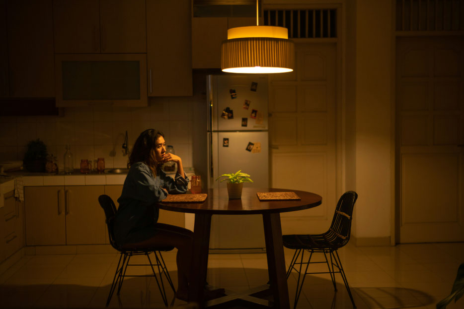 Frau sitzt alleine am Küchentisch