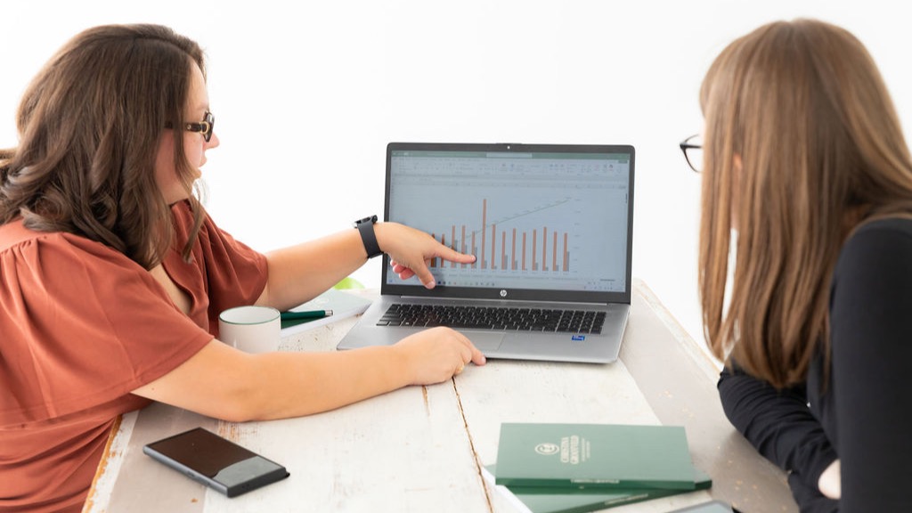 Christina Grootveld analyseert een aandeel met haar laptop, notities en beleggingsmateriaal