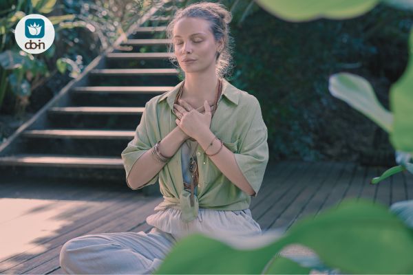 Vrouw mediteert met handen op haar hart voor bezieling via Do-In Yoga