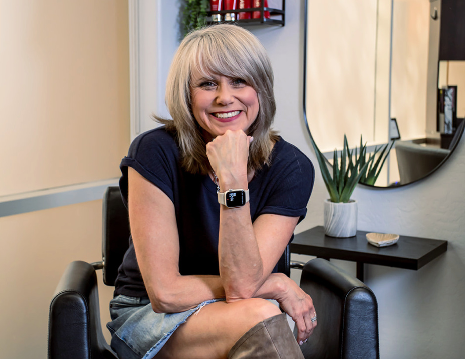 female hairstylist sitting in stylist chair