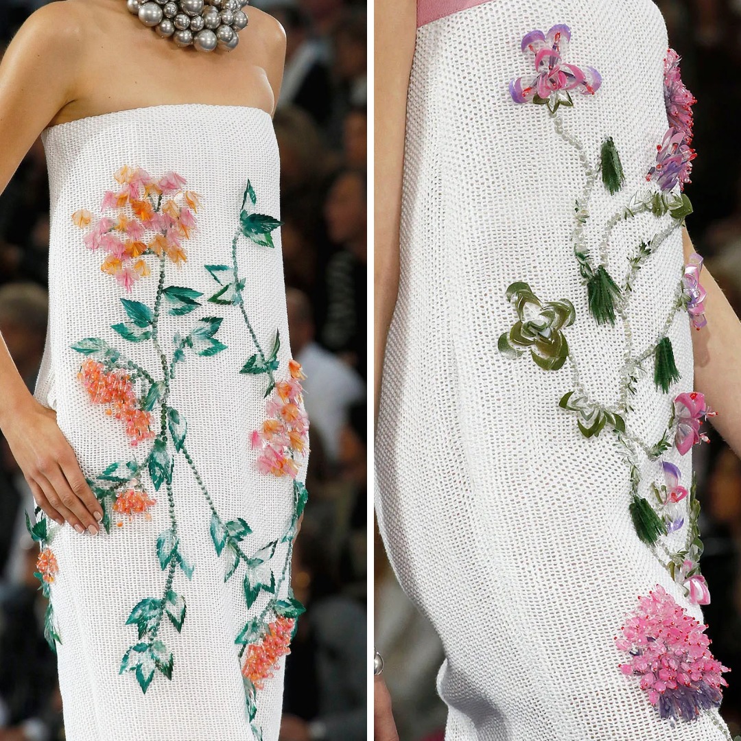 Close-up of a Chanel knit dress featuring floral embroidery combined with beadwork and dimensional elements. The dense embellishment overrides the knit structure, turning the fabric into a support for decorative surface work rather than a flexible base.