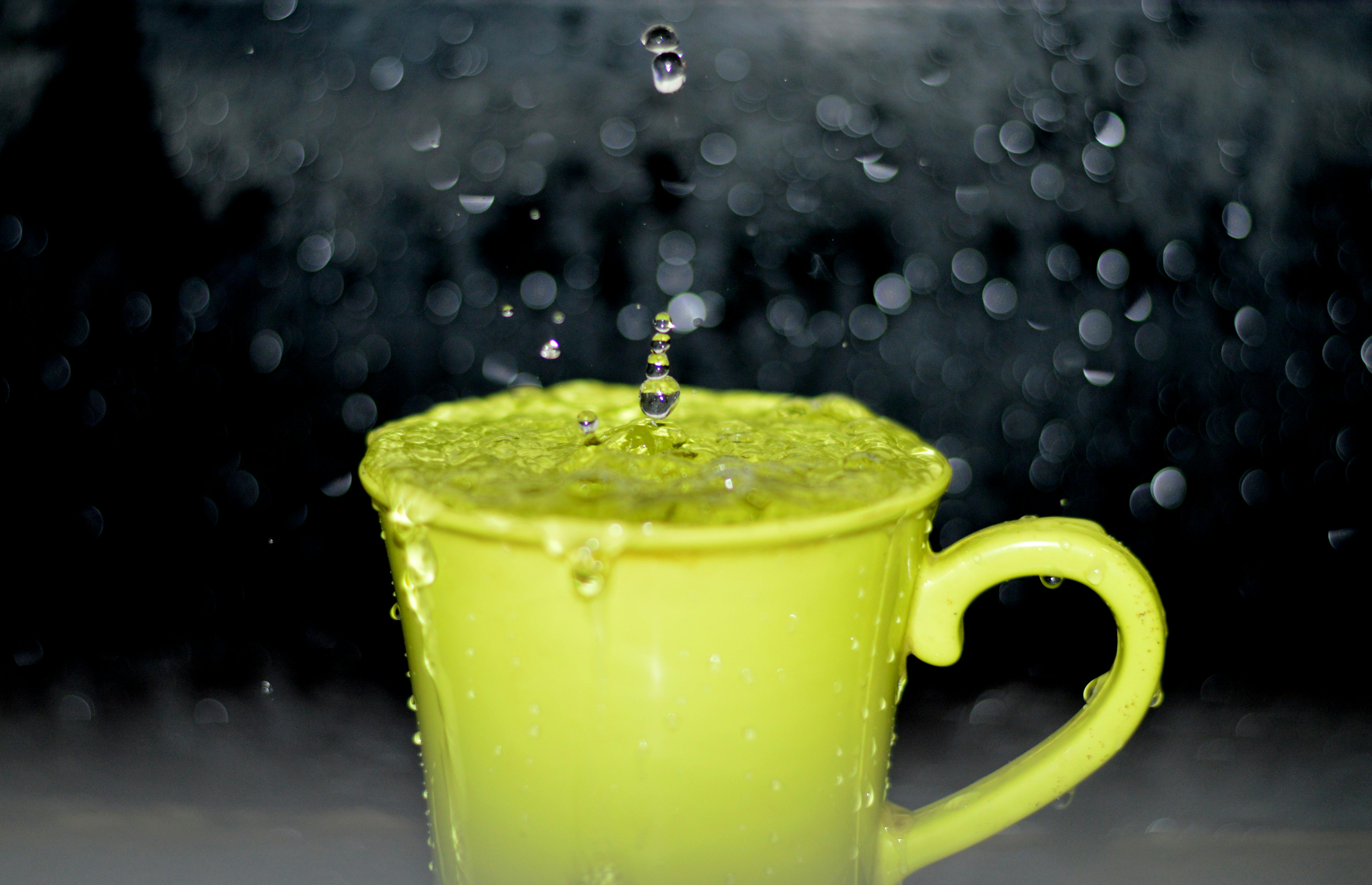 Yellow Ceramic Mug With Water Droplets in Time Lapse