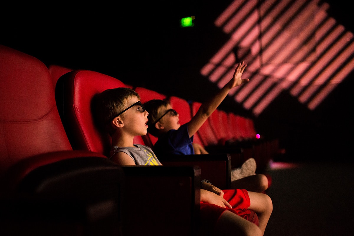 Candid photo of two kids watching a 3D movie