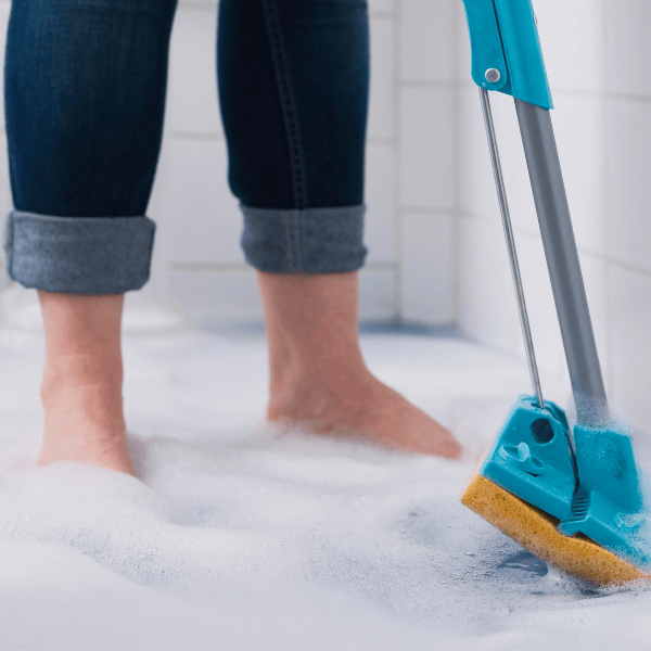 Personne qui passe la loque pour éponger l'eau qui déborde