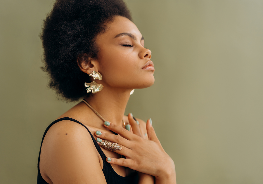  a woman with her eyes closed, hands on her chest - taking a deep breath