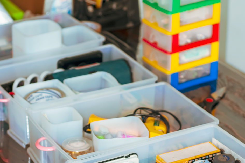 Boîtes de rangement organisées avec des objets du quotidien, illustrant le tri et l’organisation pour rester bien chez soi en vieillissant