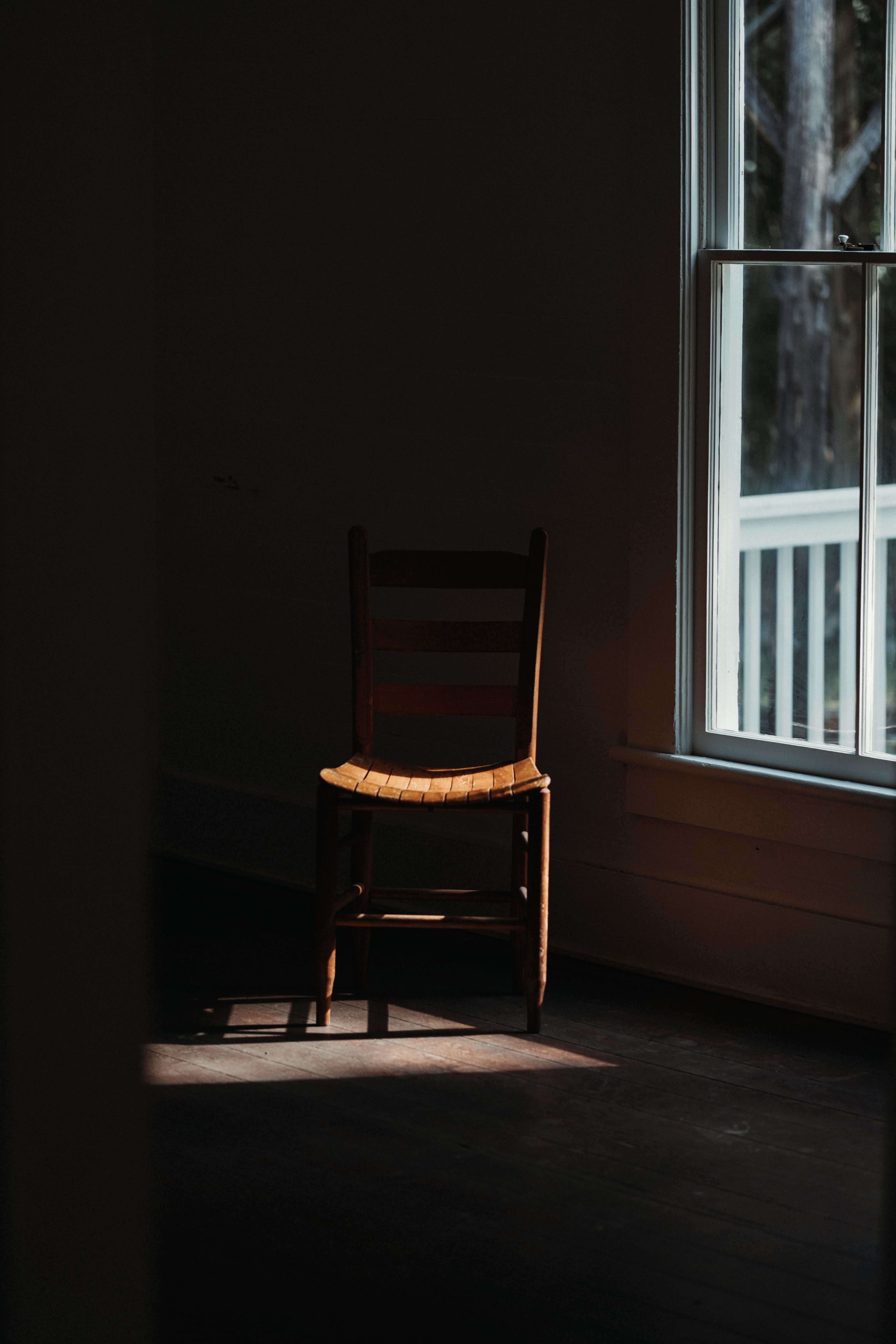 Empty chair in front of window