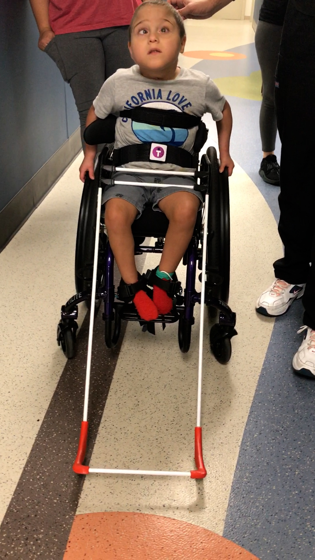 5-year-old boy in a wheelchair is wearing a belt cane