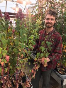 Evan Craine in a greenhouse with a lot of plants