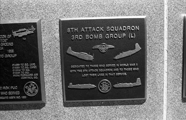A close-up of a plaque set in a series of plaques.  Other plaques can be seen to the left and right of the centered one.  The caption is in the description.