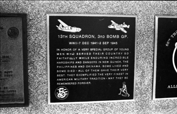 A close-up of a plaque set in a series of plaques.  Other plaques can be seen to the left and right of the centered one.  The caption is in the description.