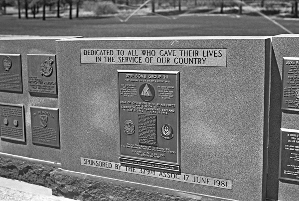 An outdoor memorial, with a central larger plaque and flanked by two sets of smaller plaques on both sides of the central one.
