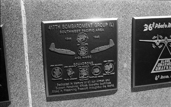 A close-up of a plaque set in a series of plaques.  Other plaques can be seen to the left and right of the centered one.  The caption is in the description.
