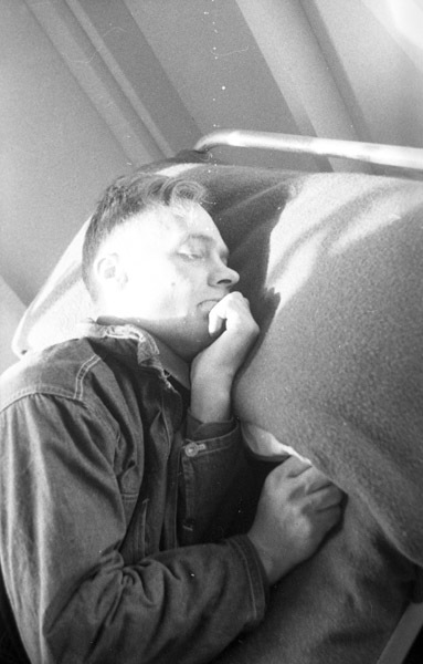 A soldier, seen from the chest up, sleeping on a bed.