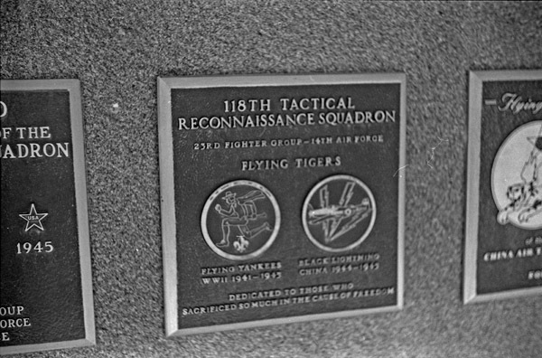 A close-up of a plaque set in a series of plaques. Other plaques can be seen to the left and right of the centered one. The caption is in the description.