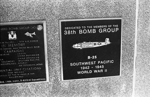 A close-up of a plaque set in a series of plaques. Other plaques can be seen to the left of the centered one.