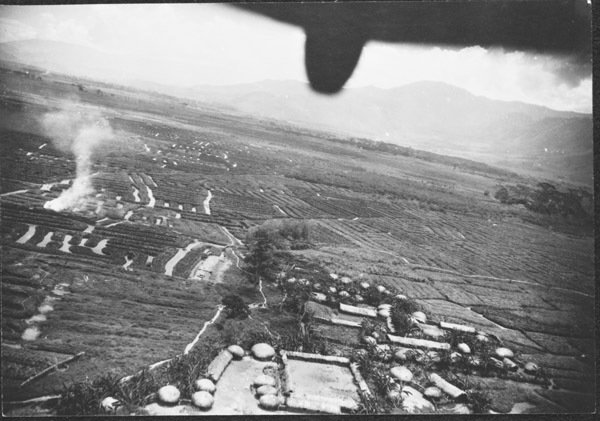 Farming fields and buildings, with the perspective from above in the back of an aircraft.