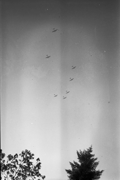 Seven planes are seen flying in the sky flying in formation.