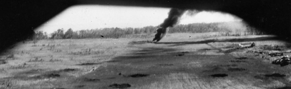 Multiple small craters in an open field, with the rearmost one billowing black smoke.