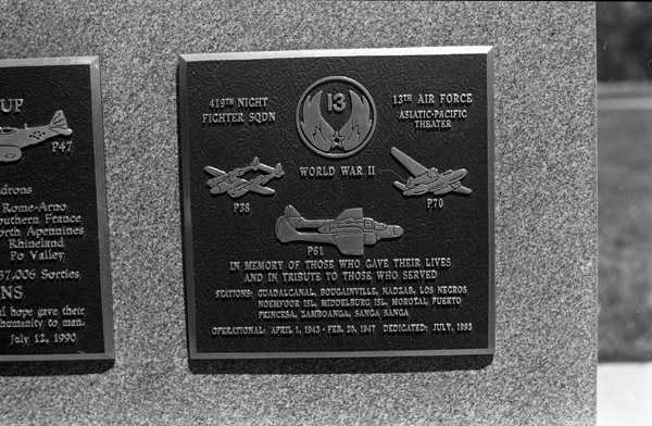 A close-up of a plaque set in a series of plaques.  Other plaques can be seen to the left of the centered one. 