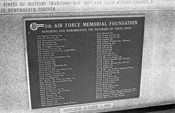 A close-up of a memorial plaque with two long lists of military units being memorialized. Many are not readable due to low resolution.