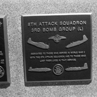 A close-up of a plaque set in a series of plaques.  Other plaques can be seen to the left and right of the centered one.  The caption is in the description.