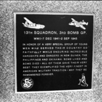 A close-up of a plaque set in a series of plaques.  Other plaques can be seen to the left and right of the centered one.  The caption is in the description.