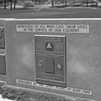 An outdoor memorial, with a central larger plaque and flanked by two sets of smaller plaques on both sides of the central one.