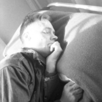 A soldier, seen from the chest up, sleeping on a bed.