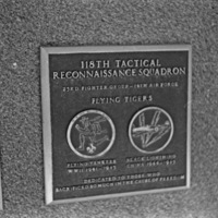 A close-up of a plaque set in a series of plaques.  Other plaques can be seen to the left and right of the centered one.  The caption is in the description.