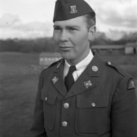 A soldier, seen from the waist up, in dress military attire and a garrison cap.